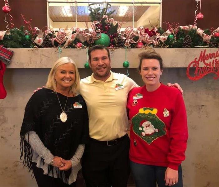 Image shows three SERVPRO employees posing at a Holiday lunch.
