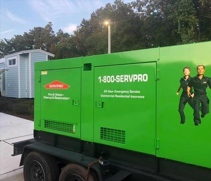 Image shows green SERVPRO generator in the foreground, and tiny house in the background.
