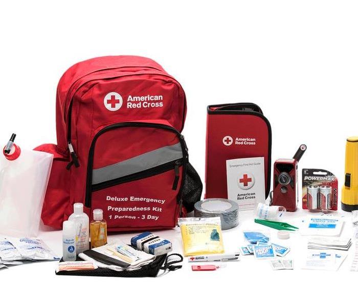 Photo shows American Red Cross Emergency Kit supplies including: batteries, flashlight, water, first aid kit, medicine, etc.