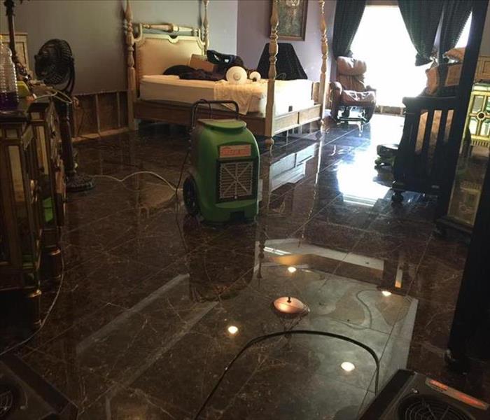 Photo shows a SERVPRO dehumidifier set up to help dry a home that flooded.
