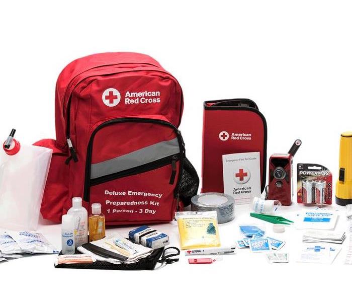 Photo shows an emergency kit from the American Red Cross with a backpack, water bottles, and first aid supplies.